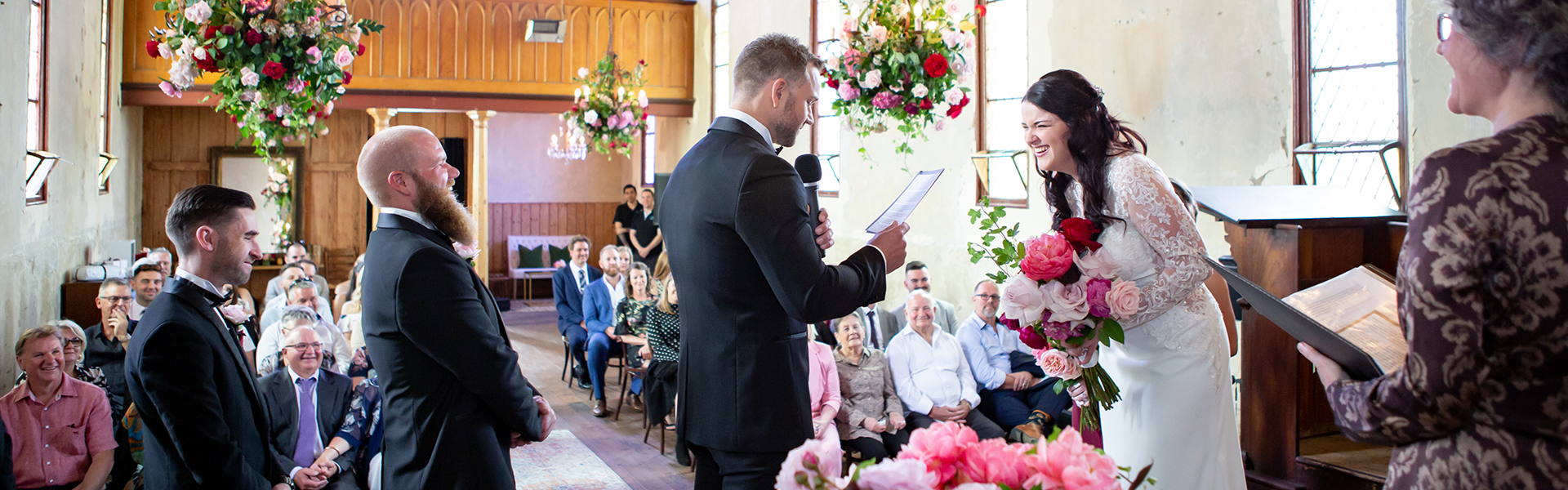 7737b212-a9e0-4b78-86f4-86d64e27f77a-celebrant jey and matt laughing while matt reads wider shot.png