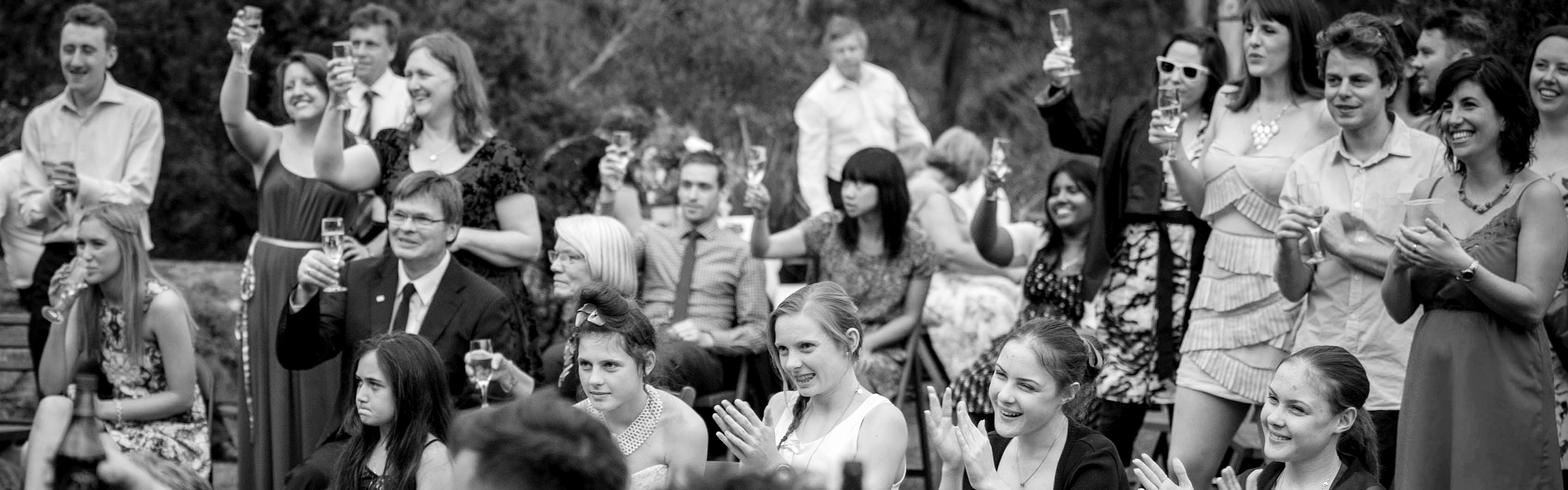 7aa97a62-c276-4344-8f70-726e0db4f63f-celebrant justine and moni guests toast cheers.jpg